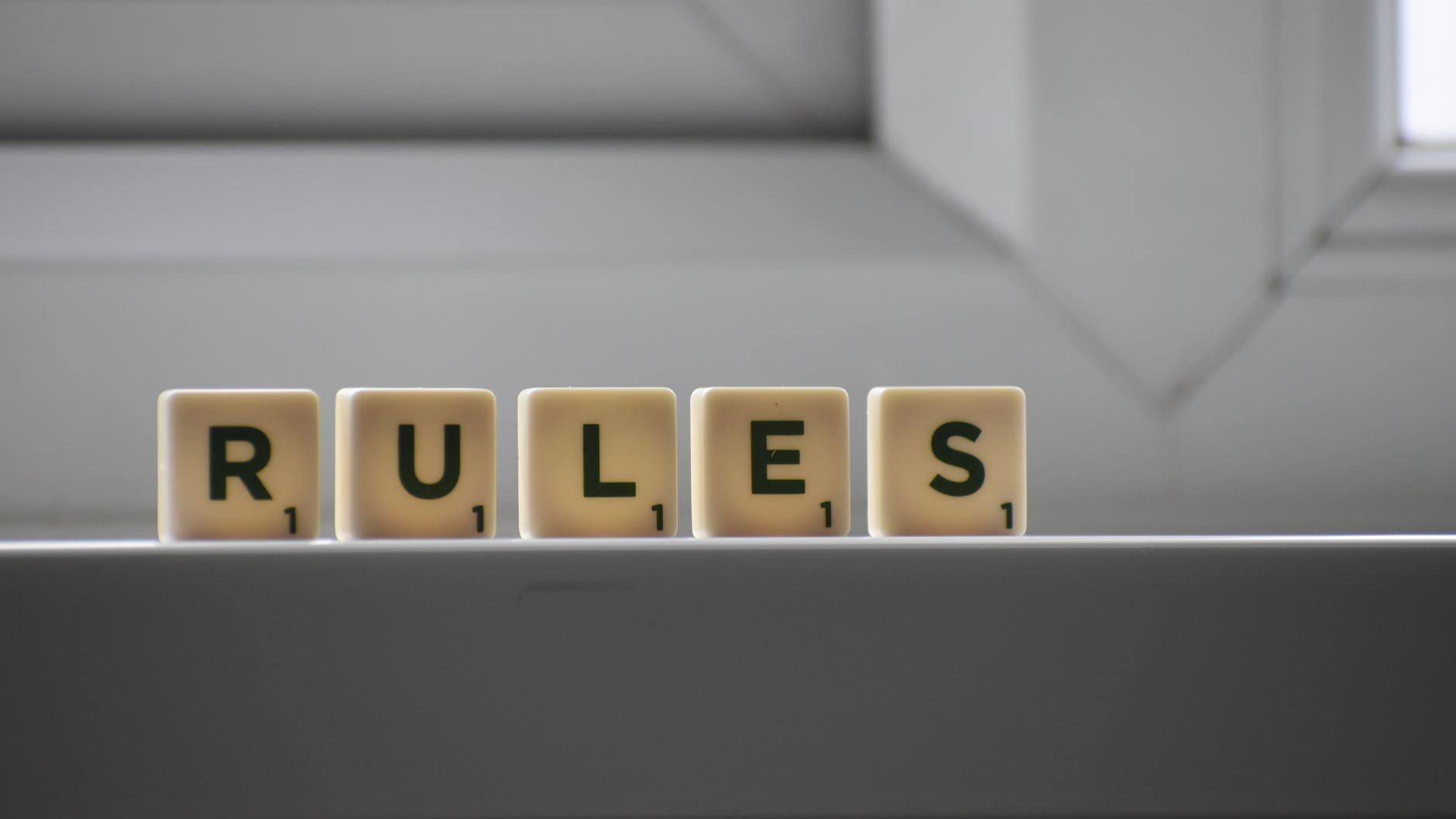 similar cubes with rules inscription on windowsill in building