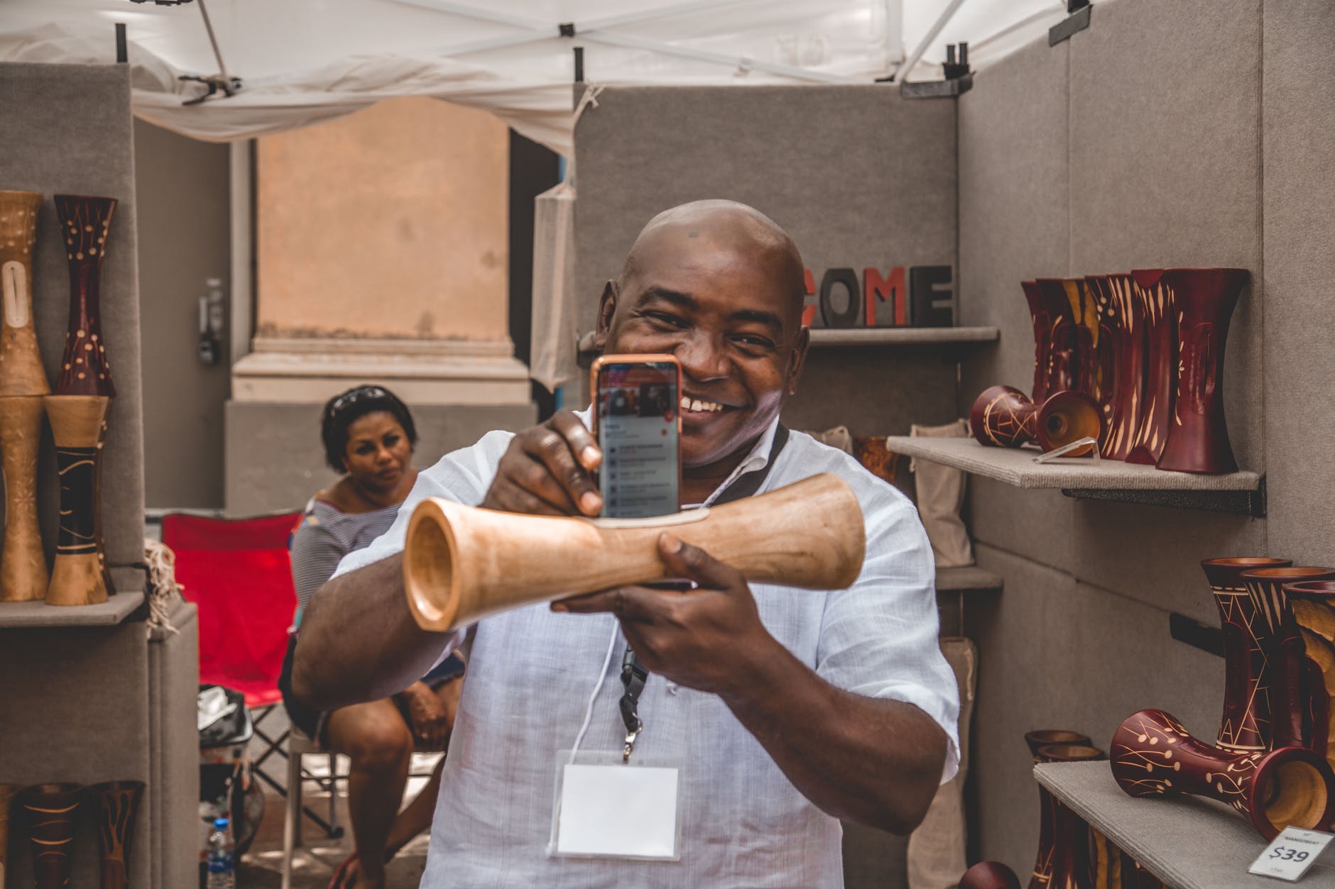 man taking photo of brown decorative speaker