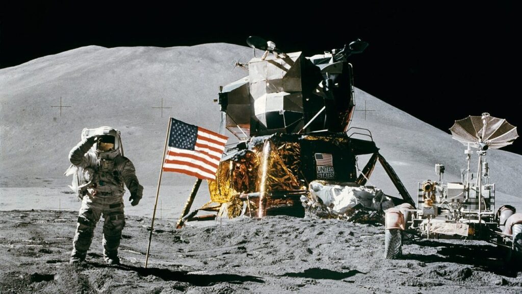 astronaut standing beside american flag on the moon