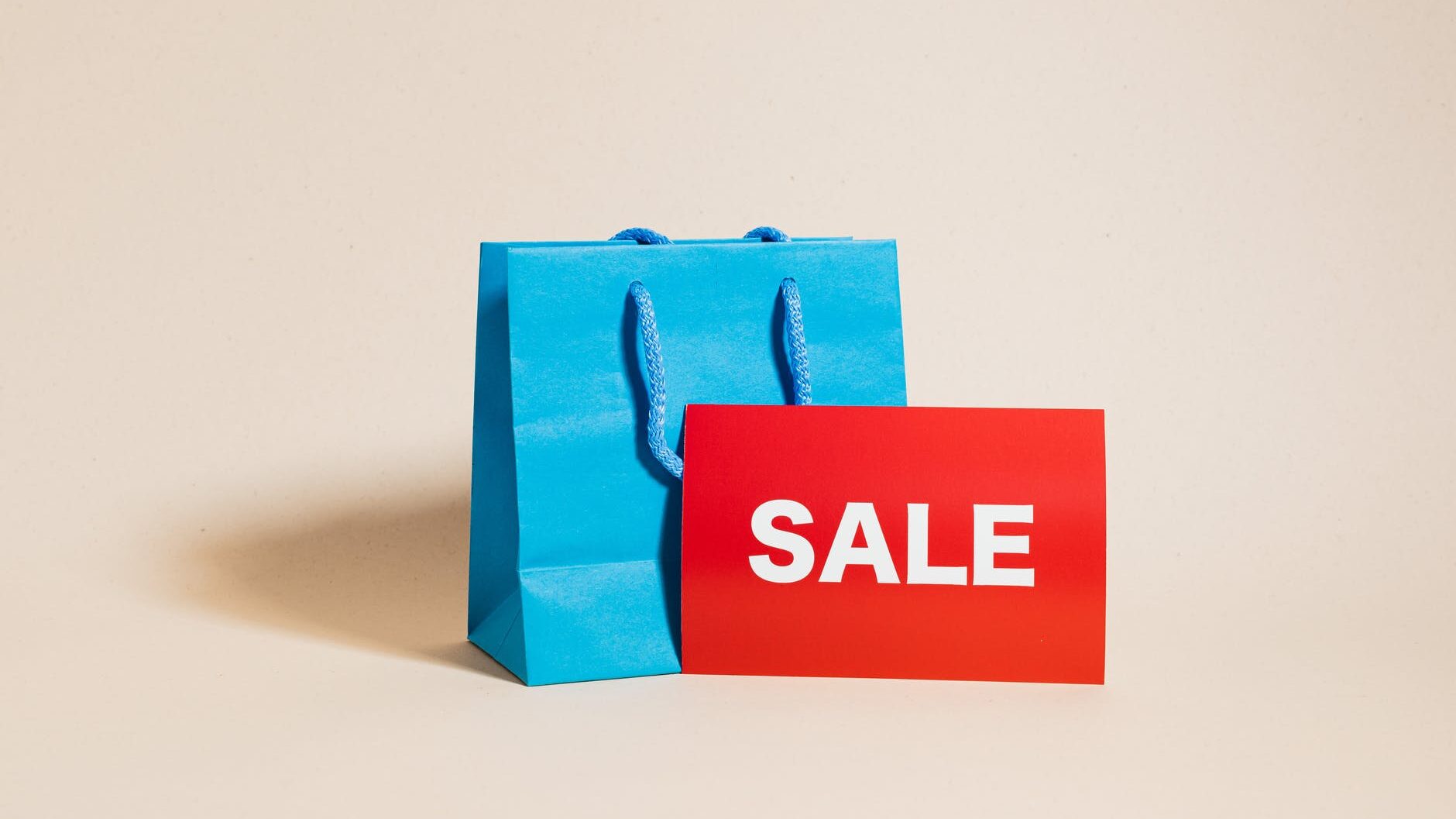 blue shopping bag and a red sale sign
