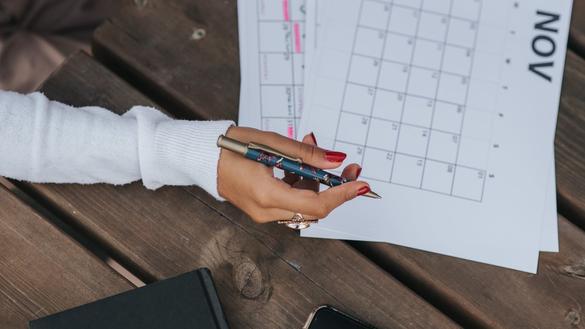 crop woman writing in calendar