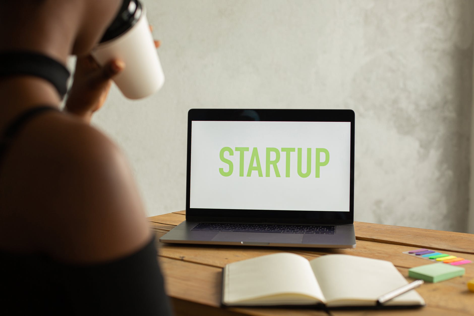 crop unrecognizable black businesswoman with laptop and coffee