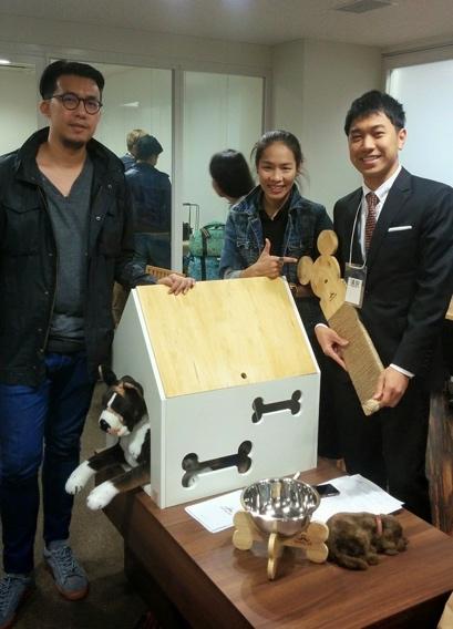 A group of people standing around a table with a cardboard box Description automatically generated with low confidence